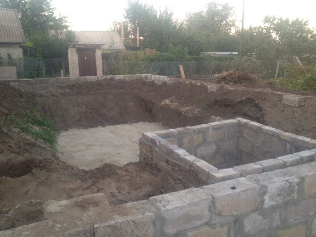 Котлован для бассейна и технический приямок из бетонных блоков на этапе строительства