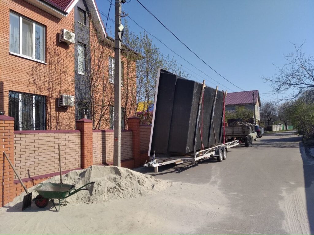 Доставка чаши бассейна на прицепе к частному дому.