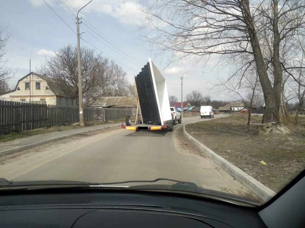 Доставка великої білої чаші композитного басейну на спеціальному причепі по дорозі до клієнта