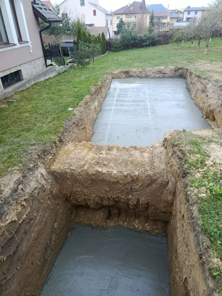 Котлован под бассейн с бетонной плитой и отдельная яма под приямок.