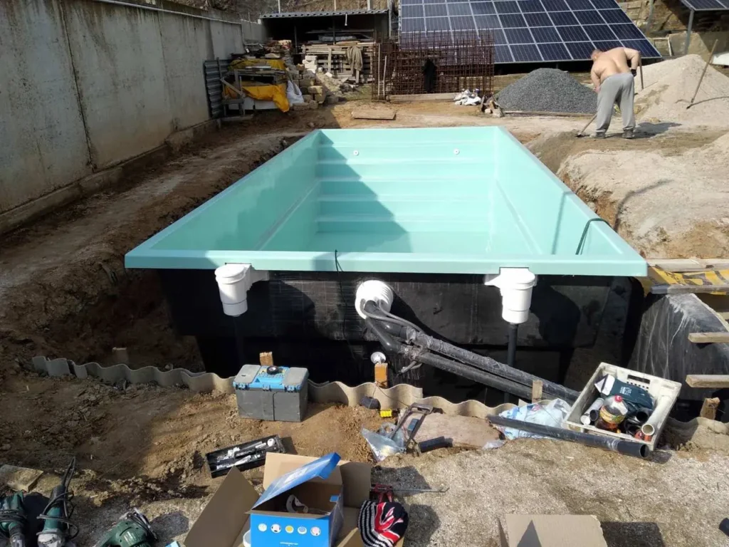 Монтаж композитного бассейна: скиммеры и трубы обвязки на внешней стенке чаши.