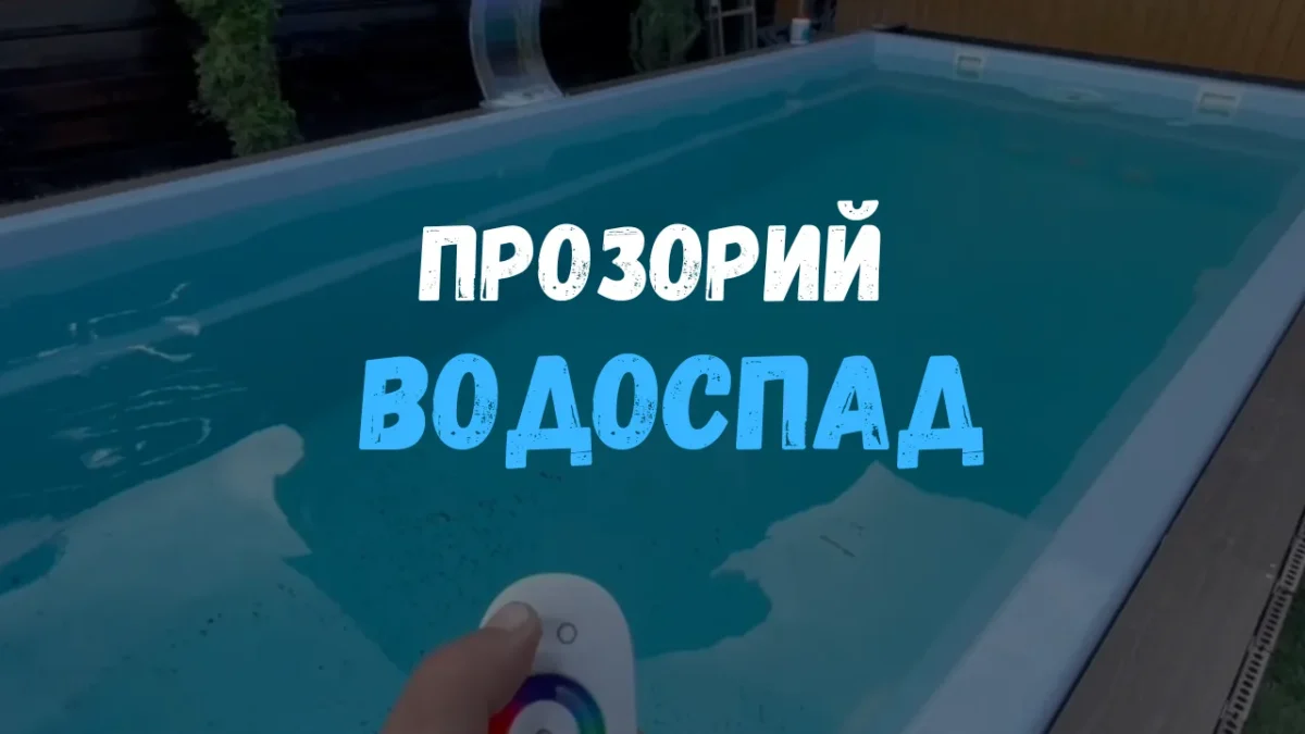 Прозрачный водопад с подсветкой на борту композитного бассейна Luna 6м, в руке пульт управления цветом — кадр из видео.